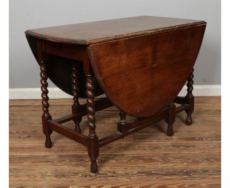An oak drop leaf gate leg table, featuring barley twist supports. Height: 72cm, Width (extended): 150cm, Depth: 106cm.
