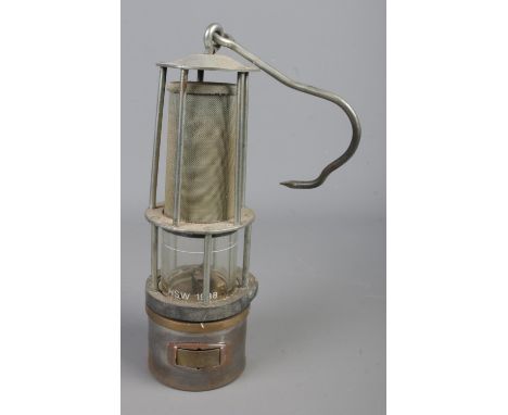 A vintage Davy miners safety lamp with protective gauze and swing handle. Glass inscribed 'HSW 1988' .