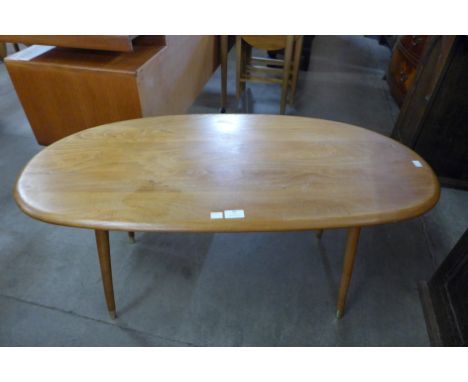 An Ercol Blonde elm topped coffee table, on associated beech legs 