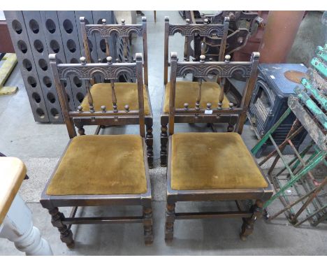 A set of four Ercol carved oak dining chairs 