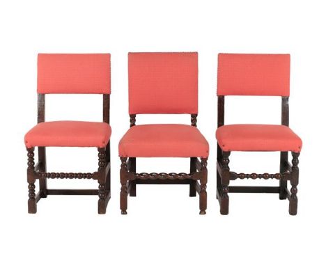 A Harlequin Set of Nine Joined Oak Back Stools, later upholstered in close-nailed pink fabric, with padded back supports and 