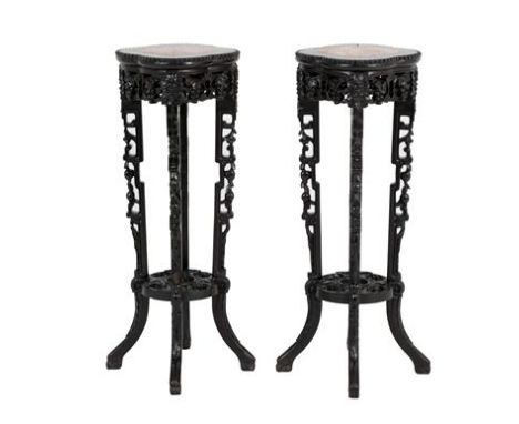 A Pair of Early 20th Century Chinese Padouk Wood and Pink Marble Plant Stands, with beaded borders above foliate carved friez