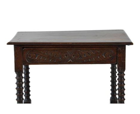 {} A Late 17th Century Oak Side Table, the three-plank top above a carved drawer and frieze, on bobbin turned legs with block