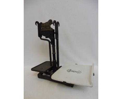 A Victorian shopkeeper's scale surmounted by a recumbant bull, with a white porcelain slab.
