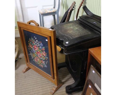 A late Victorian ebonised Davenport desk together with a firescreen inset a woolwork panel