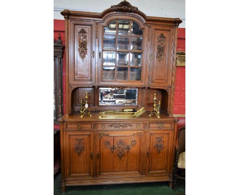 A substantial French Rococo style side cabinet, outswept arched cornice crested by scrolling acanthus and flowerheads, above 