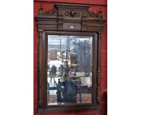 A substantial 19th century mahogany framed looking glass, outswept cresting above a central panel applied with and flanked by