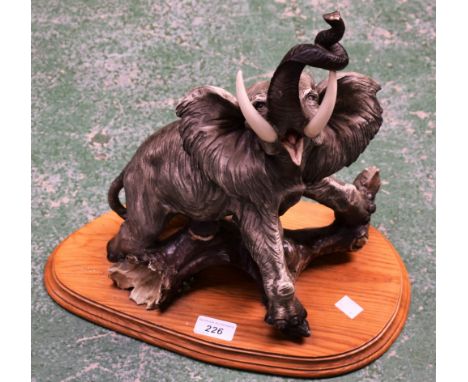 Auro Belcari, after, resin model of an elephant with trunk raised, wooden base, approx 40cm high overall