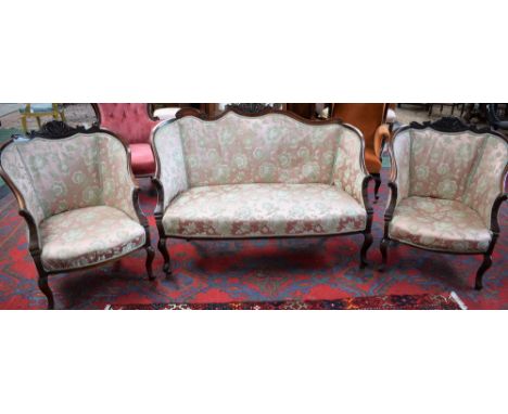 A Victorian mahogany three piece salon suite comprising sofa and a pair of chairs, each back crested by and terminating in sc