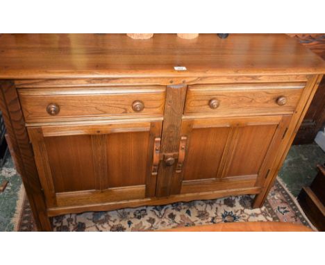 An Ercol sideboard, rounded rectangular top above a pair of short drawers, the left enclosing a sliding cutlery tray, and a p