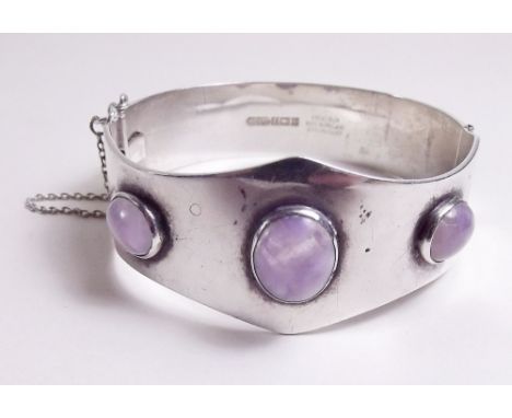 A silver hinged bangle set three amethysts 