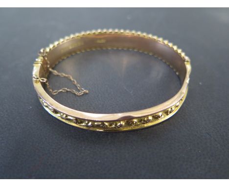 A 9ct yellow gold bangle - approx weight 10 grams - 6.5cm x 5.5cm - some denting but clasp working