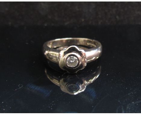 An 18ct white gold ring with flower form mount and diamond centre. Size J/K, 4.2g