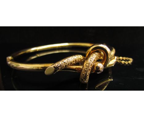 A gold stiff hinged bangle of Knot design and engraved decoration, 9g