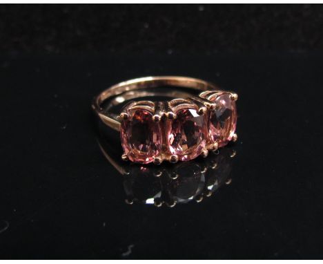 A 9ct rose gold pink tourmaline three stone ring. Size N/O, 2.1g with certificate