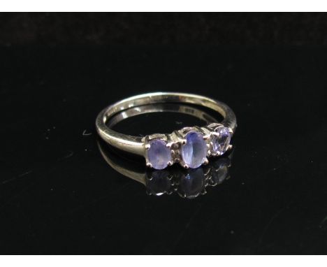 A 9ct white gold three stone tanzanite ring. Size O, 1.6g