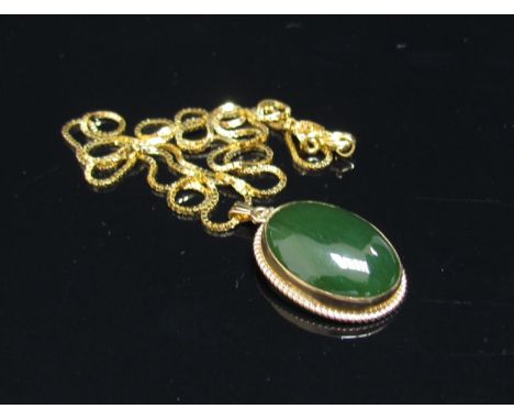 An oval cabochon jade pendant in 10k mount hung on a gold box chain stamped 750, 46cm long, 5.1g total