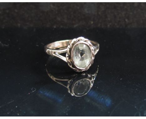A white gold ring set with oval aquamarine in rope twist mount stamped 18ct. Size J/K, 2.5g