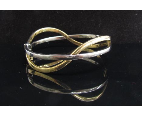 A two tone gold wavy bangle stamped 375, 9.9g