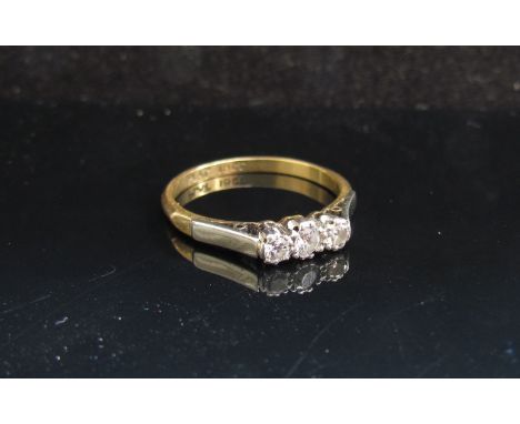 A gold platinum set three stone diamond ring, stamped 18ct. Size N, 2.2g