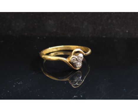 A gold ring with three diamonds in a crossover setting, stamped 18ct. Size U, 3.1g