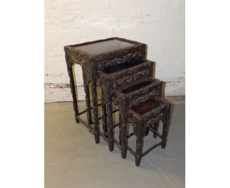 A nest of four Chinese tables, the borders carved with dragons and cloud scroll, Widths 11.5” to 20”