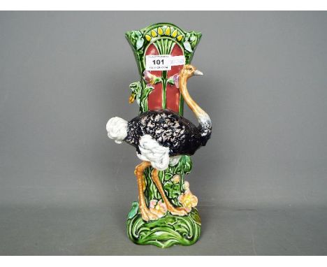 A late 19th / early 20th century majolica vase with ostrich figure and floral decoration, approximately 30 cm (h).Condition R