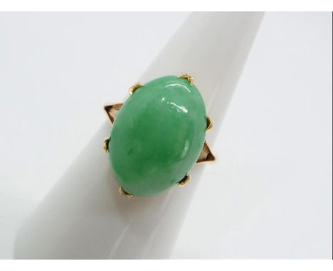 A yellow metal unmarked dress ring (presumed 14k) with cabochon jade stone measuring 1.6 x 11 cm, size N, approx weight 3.89g