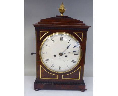 A George III mahogany cased bracket clock with a stepped top, gilt metal pineapple finial and brass ring handles, over scale 