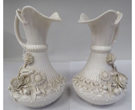 A pair of Belleek pearl ivory glazed porcelain ewers of bulbous form with narrow necks, flared rims, double C-scrolled handle