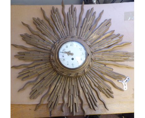 An early 20thC carved giltwood cased sunburst wall clock; the movement faced by a convex white enamel Arabic dial and brass b