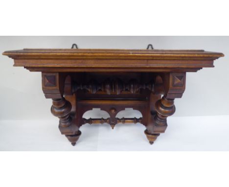 A late Victorian walnut clock bracket, the platform top over a series of elaborately turned supports and pendant finials&nbsp