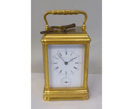 An early 20thC French lacquered brass cased carriage clock with a folding top handle and bevelled glass panels; the gong stri