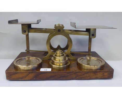 Late Victorian S.Mordan &amp; Co, London, lacquered brass beam balance postal scales, attached to an oak plinth with eight gr