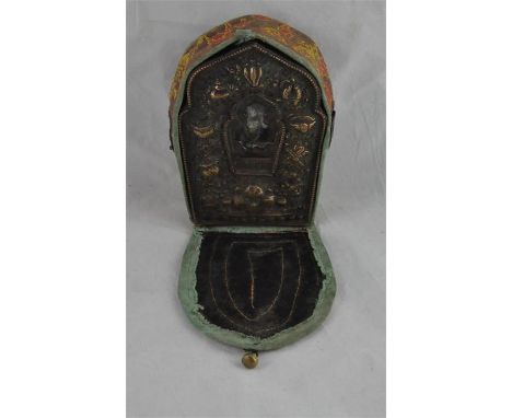 An 18th century Tibetan Phua copper gilt metal mihrab shaped personal altar, with embossed decoration around a glass panel sh