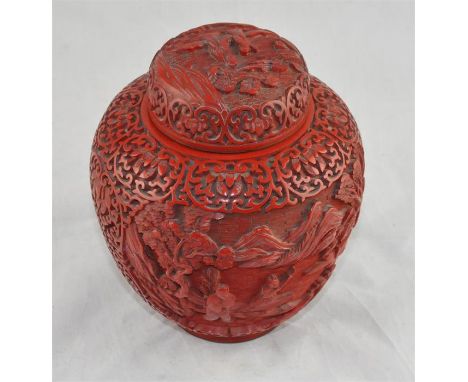 A 19th century Chinese ovoid cinnabar jar and cover, decorated in raised relief with figures in landscapes amidst pierced C s