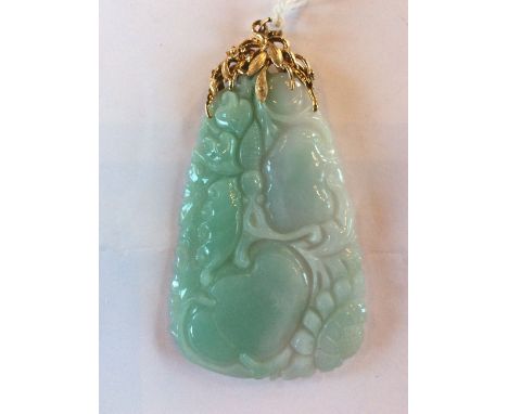 A large Chinese 14ct. yellow gold and mottled green jade pendant, of adze form, engraved with foliage, within openwork leaf a