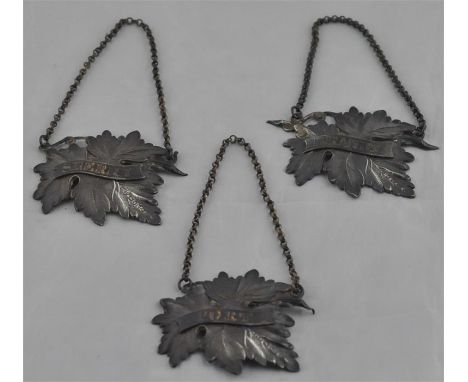 A matched set of three mid 19th century vine leaf form silver decanter labels, hallmarked for Birmingham, various makers and 