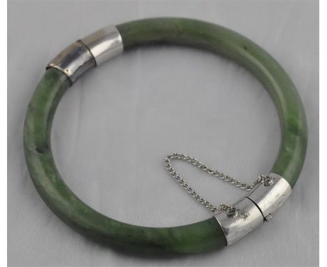 A spinach jade bangle, of circular cross-section and form, with white metal&nbsp;hinge and clasp, external diameter 7.3cm.