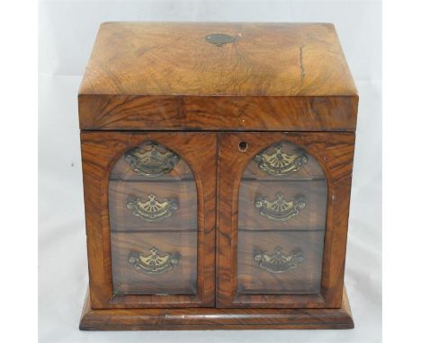 A walnut jewellery cabinet, the gently domed hinged top opening to reveal fitted jewellery tray and four compartment scent bo