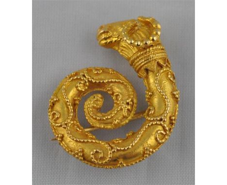 A yellow metal rams head ring and matching brooch set,&nbsp; in the archaic style, the ring fashioned as a pair of rams' head