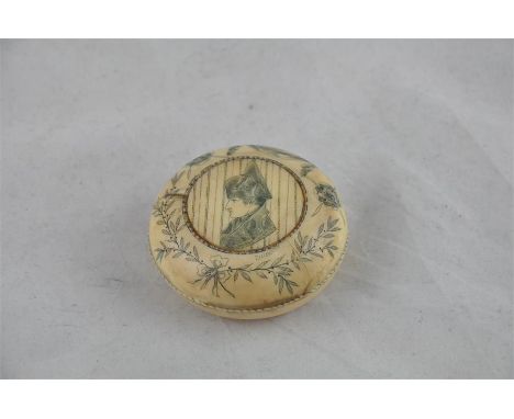 An early 19th century Napoleonic ivory circular box and cover, engraved with a bust of Napoleon, within floral borders initia