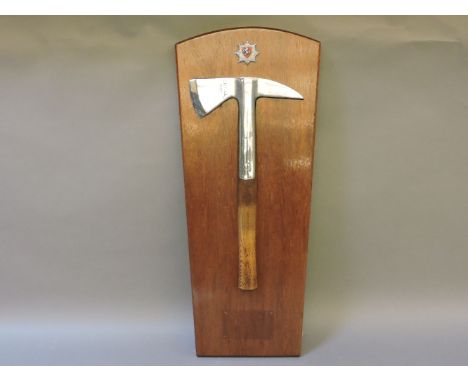 A presentation fireman's axe, mounted on a mahogany board, 61cm long