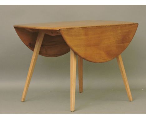 A circular Ercol drop leaf dining table, 114ccm diameter, 72cm high