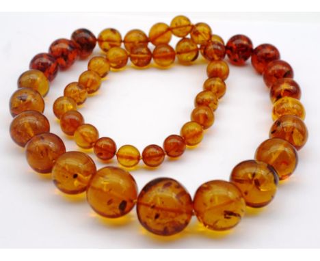 Baltic amber graduated bead matinee necklace. Natural amber showing a cognac colour with natural inclusions. Approx 12mm-25mm