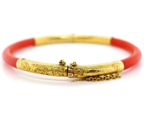 Oriental coral and gold bangle hinged with box clasp and safety chain makers mark. 58mm inside width. Metal tests as 18ct.