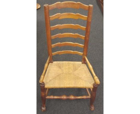 19th century American oak ladder back armchair with turned arms and replaced rush seat, raised on turned legs joined by turne