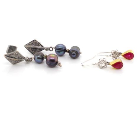 Two pair of decorative earrings includes treated ruby drops and a black pearl and diamond set example.