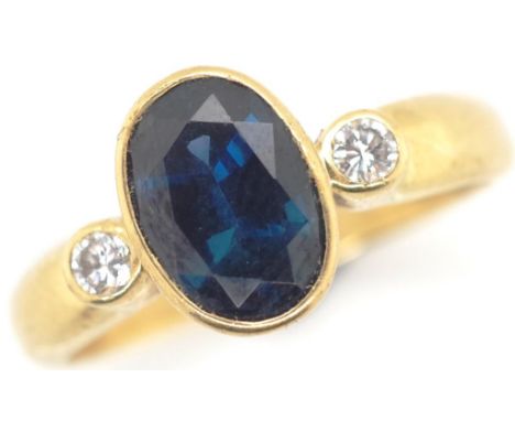 A good sapphire and diamond 18ct gold ring marked 18ct to shank approx oval cut sapphire 8.4mm x 8.2mm and two bezel set roun