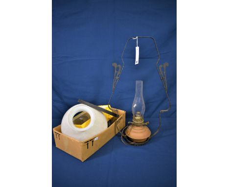 A late 19th century oil lamp with brass reservoir in wrought iron ceiling hanging frame with milk glass shade, converted to e